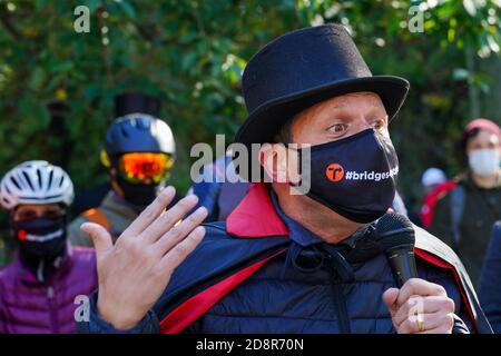 A protester wearing a face mask and costume speaks during a demonstration.Cyclists wearing costumes rode their bikes from the respective boroughs to Gracie Mansion to protest for more space for pedestrians and cyclists on dangerously overcrowded bridges. Stock Photo