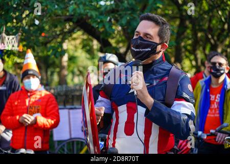 A protester wearing a face mask and costume speaks during a demonstration.Cyclists wearing costumes rode their bikes from the respective boroughs to Gracie Mansion to protest for more space for pedestrians and cyclists on dangerously overcrowded bridges. Stock Photo
