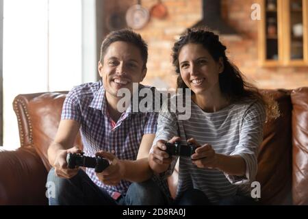 Smiling couple have fun playing video games Stock Photo
