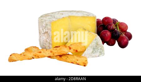 Farmhouse cheddar cheese wheel with red grapes and crispy baked cheese bread twists isolated on a white background Stock Photo