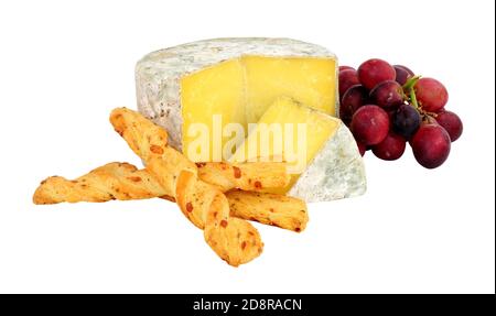 Farmhouse cheddar cheese wheel with red grapes and crispy baked cheese bread twists isolated on a white background Stock Photo