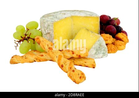 Farmhouse cheddar cheese wheel with red, green grapes and crispy baked cheese bread twists isolated on a white background Stock Photo