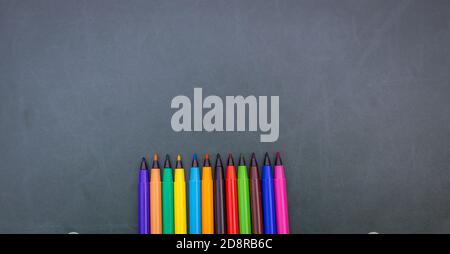 Colorful sketch pen on a green board at school with copyspace. Stock Photo