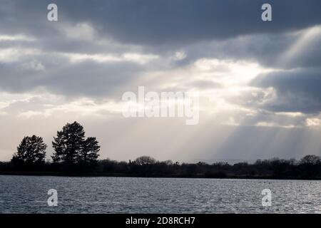 Sun rays shining through dark clouds over Lake Taupo, Tokaanu, near Turangi, North Island, New Zealand Stock Photo
