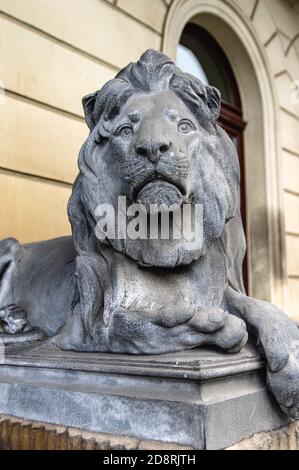 decorative bronze statue of a male lion in front of a building