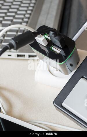 Electrical USB charger plug for four USB cable on a desk. Battery charger for digital devices Stock Photo