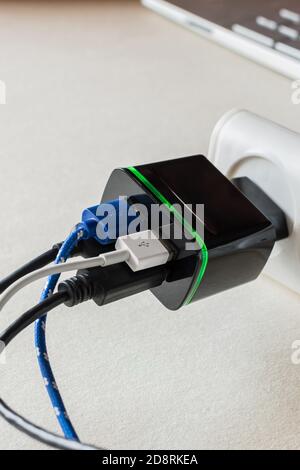 Electrical USB charger plug for four USB cable on a desk. Battery charger for digital devices Stock Photo