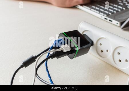 Electrical USB charger plug for four USB cable on a desk. Battery charger for digital devices Stock Photo