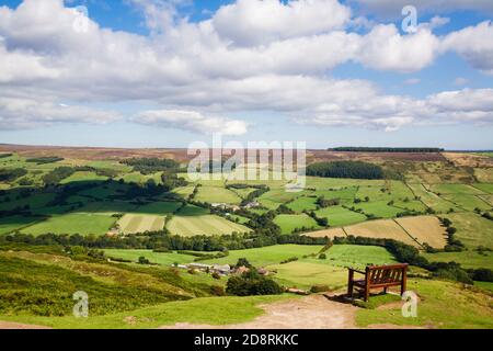Bench on Rosedale Moor with view of green fields in Esk Dale valley in North York Moors National Park in summer.  Rosedale Abbey Yorkshire England UK Stock Photo