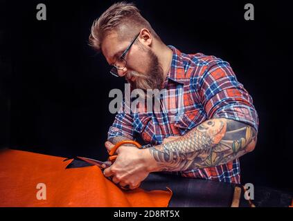 Currier wording with leather goods at the leather studio Stock Photo