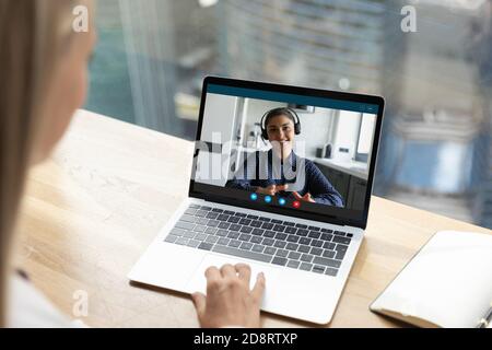 Close up rear view businesswoman chatting with Indian colleague online Stock Photo