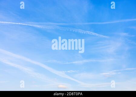 several old contrails and cirrus clouds in blue sky on autumn day Stock Photo