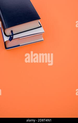 Vertical shot of books on an orange surface Stock Photo
