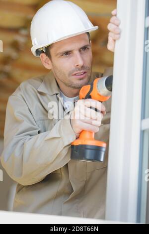 male builder during process of windows installation Stock Photo