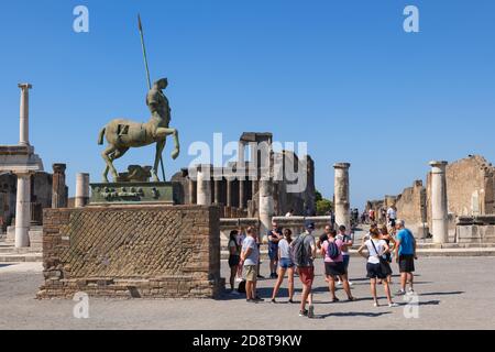 Pompeii Forum with statue of Centaur, Campania, Italy, group of people, tourists on a sightseeing tour Stock Photo