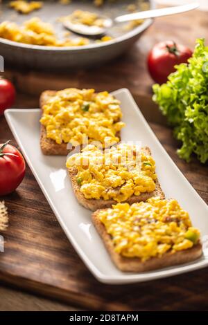 Scrambled eggs on toasts served on a plate Stock Photo