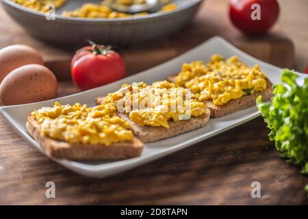 Scrambled eggs on toasts served on a plate Stock Photo