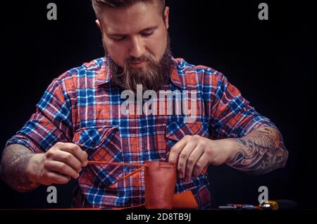 Leather Worker produces leather goods at the leather shop Stock Photo
