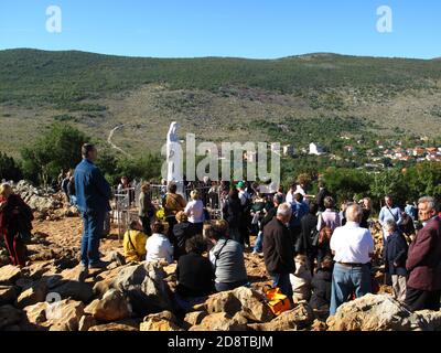 Our Lady of Medjugorje. Pilgrims praying bye the Virgin Mary statue on the apparition hill where believed that she had appeared for six local children Stock Photo