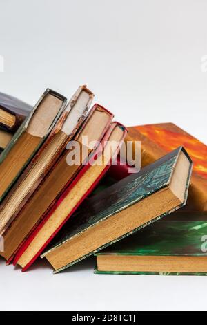 Collapsed row of old books with ancient bindings on a white background Stock Photo