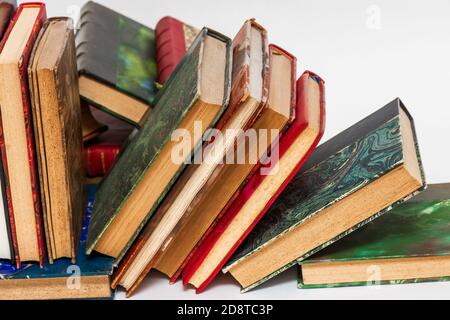 Collapsed row of old books with ancient bindings on a white background Stock Photo