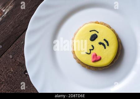 Closeup of a cookie with decorated funny smiley faces on a plate Stock Photo