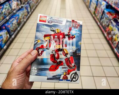 Puilboreau, France - October 14, 2020: Closeup of Man hand buying Avenger Marvel figurine Lego brand display for sell in french supermarket Stock Photo