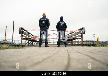 Nordenham, Germany. 01st Nov, 2020. Two police officers guard the Union Pier in Nordenham, where the ship with six castors of highly radioactive nuclear waste is expected to arrive. Credit: Mohssen Assanimoghaddam/dpa/Alamy Live News Stock Photo