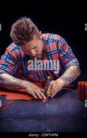 Artist working with leather creating leatherwork Stock Photo