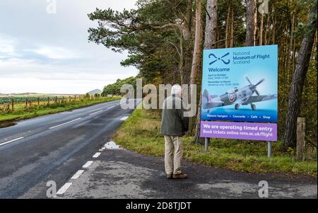 Senior man looking at sign with Spitfire areoplane, National Museum of Flight, East Fortune, East Lothian, Scotland, UK Stock Photo