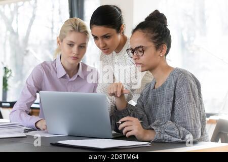 Focused diverse colleagues working on online project presentation. Stock Photo