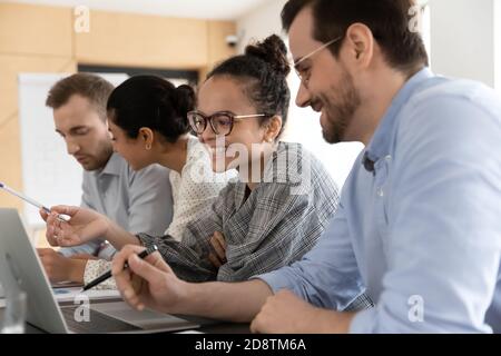 Happy smiling multiracial colleagues working on computers in office. Stock Photo