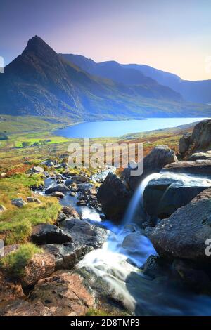 Small Waterfall with Tryfan and Lyl Ogwen in the background on a Sunny day, Snowdonia National Park, North Wales, UK. Stock Photo