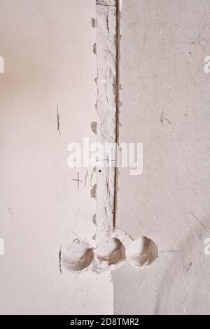 Holes in a concrete wall for installing plastic boxes under sockets. installation of sockets in a concrete wall and wiring. Professional draft Stock Photo