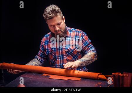 Artist working with leather processing a leather workpiece Stock Photo
