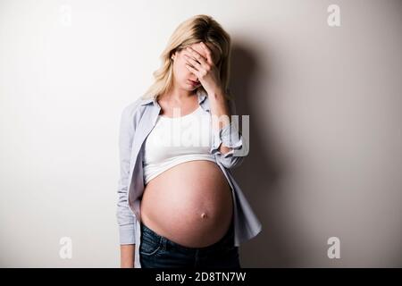 Pregnant woman with a lot of stress on white background Stock Photo