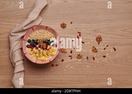 Healthy snacks in bowl: yoghurt, oat flakes, apple, blueberries, walnuts, goji and chia seeds. Superfood. Concept of healthy eating, healthy lifestyle Stock Photo