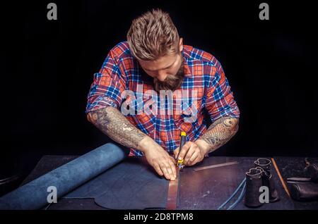 Handicraftsman processing a leather workpiece Stock Photo