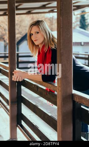 Portrait of attractive young caucasian blonde woman leaning on rail guard in balcony Stock Photo