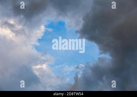 natural blue sky window in clouds, round gap in solid summer clouds Stock Photo