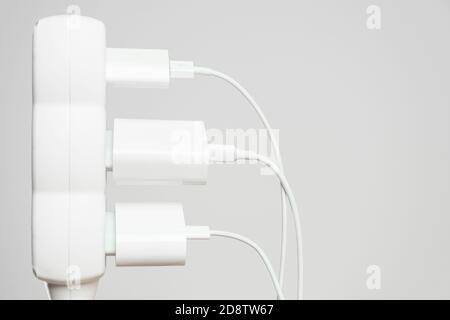 Indoor white office extension cord with three white connected to it power plugs with copy space Stock Photo