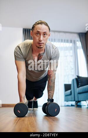 mMn doing push-ups with dumbbells Stock Photo