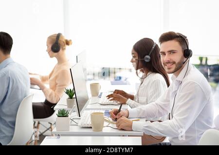 Diverse customer service operators helping clients, resolving technical issues or selling goods at call centre Stock Photo