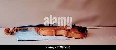 Violin with bow and blue folder for music sheets on table Stock Photo