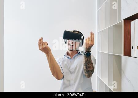Excited man in VR headset Stock Photo