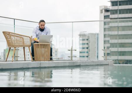 Young man working on rooftop Stock Photo