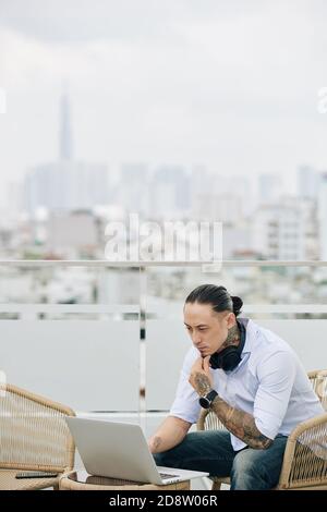 Pensive man working on rooftop Stock Photo