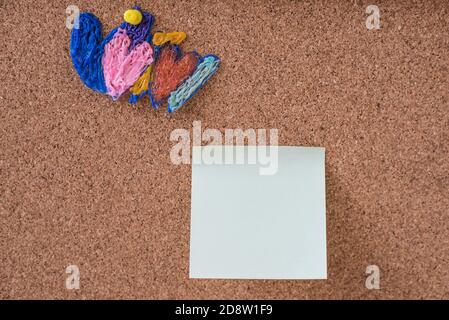 Colorful hearts pinned to corkboard near memory sticker Stock Photo