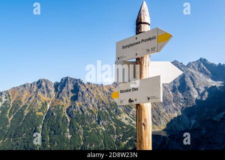 Mountain trail wooden directional sign in Tatra Mountains, pointing direction to Morskie Oko lake (Eye of the Sea) and Szpiglasowa Przelecz Pass. Stock Photo