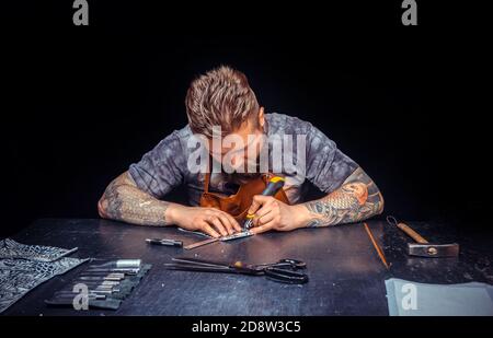 Leather Artist produces leather goods in the workshop Stock Photo